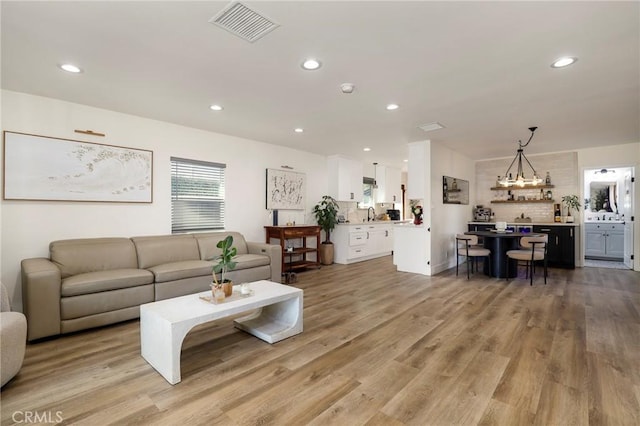 living room featuring a chandelier and light hardwood / wood-style flooring