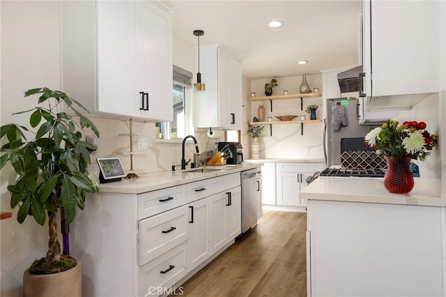 kitchen with white cabinetry, sink, pendant lighting, and appliances with stainless steel finishes