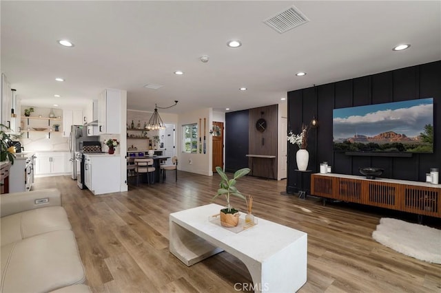 living room with a chandelier and light wood-type flooring