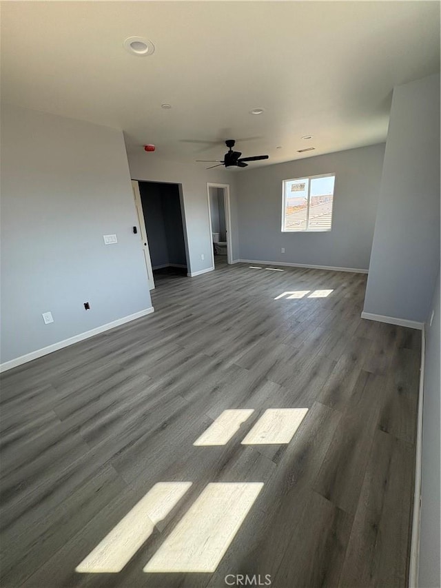 empty room featuring dark wood-type flooring and ceiling fan