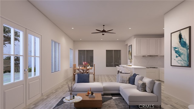 living area with recessed lighting, plenty of natural light, a ceiling fan, and light wood finished floors