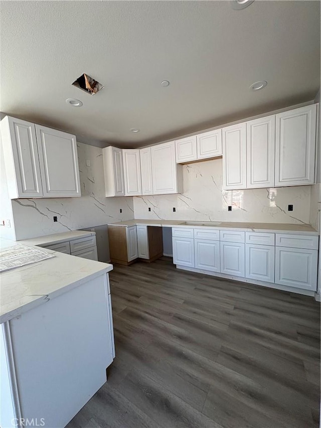 kitchen with tasteful backsplash, white cabinetry, and dark hardwood / wood-style floors