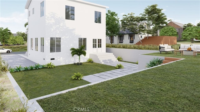 rear view of property with stucco siding and a yard