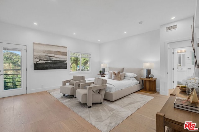 bedroom with multiple windows, access to outside, and light hardwood / wood-style floors