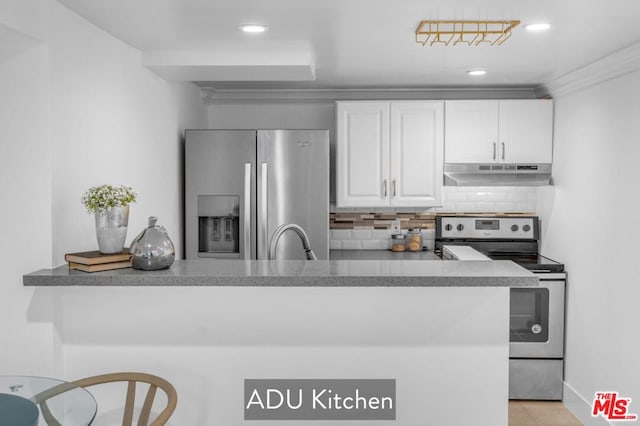 kitchen with sink, white cabinets, backsplash, kitchen peninsula, and stainless steel appliances