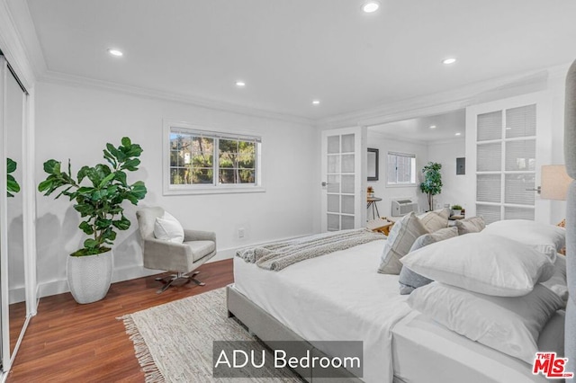 bedroom featuring ornamental molding, dark hardwood / wood-style floors, and a wall mounted air conditioner