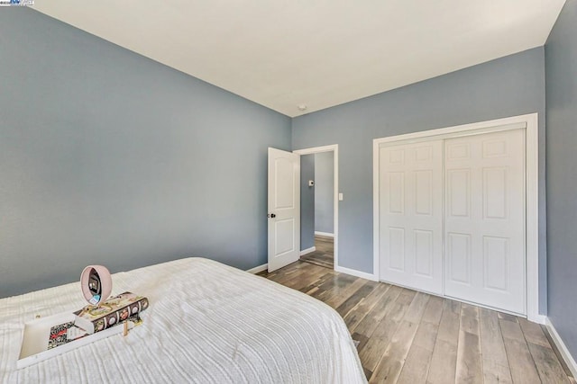 bedroom with a closet and dark hardwood / wood-style floors