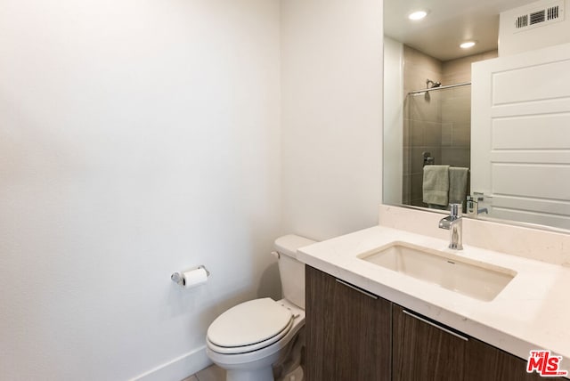 bathroom featuring an enclosed shower, vanity, and toilet