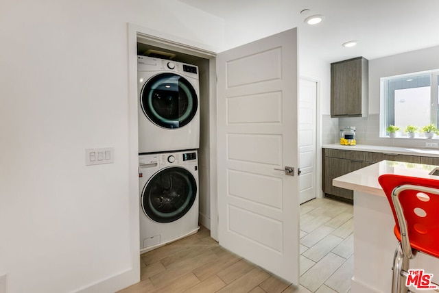 laundry room featuring stacked washer / drying machine