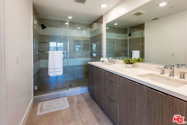 bathroom featuring tile patterned floors, a shower with shower door, and vanity