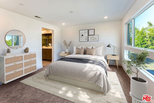 bedroom featuring ensuite bathroom and carpet floors