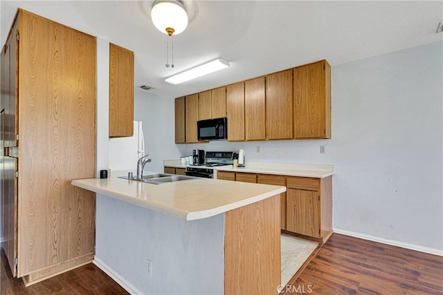 kitchen with hardwood / wood-style flooring, sink, kitchen peninsula, and black appliances