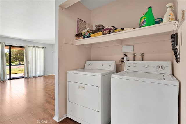 clothes washing area featuring hardwood / wood-style flooring and washer and clothes dryer