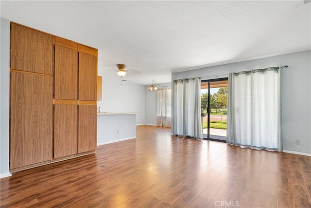 unfurnished room featuring ceiling fan, dark wood-type flooring, and a textured ceiling