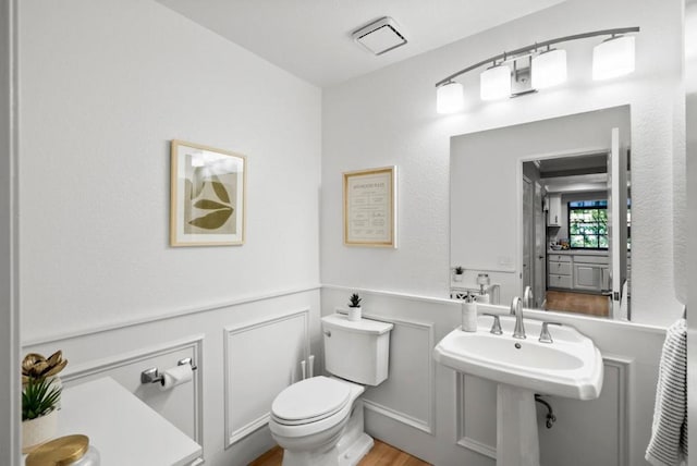 bathroom with hardwood / wood-style flooring, toilet, and sink