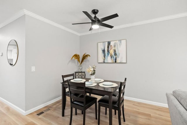 dining area with hardwood / wood-style flooring, ornamental molding, and ceiling fan