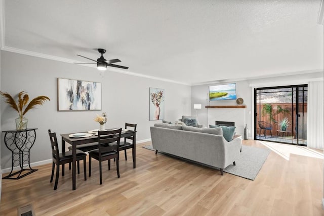 living room featuring ornamental molding, light hardwood / wood-style floors, and ceiling fan