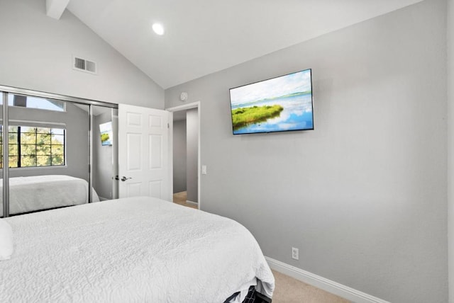 carpeted bedroom with vaulted ceiling with beams and a closet