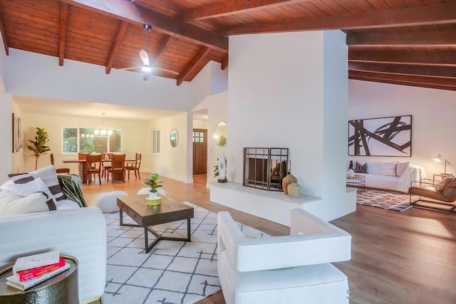 living room featuring light hardwood / wood-style flooring, beamed ceiling, an inviting chandelier, and wooden ceiling