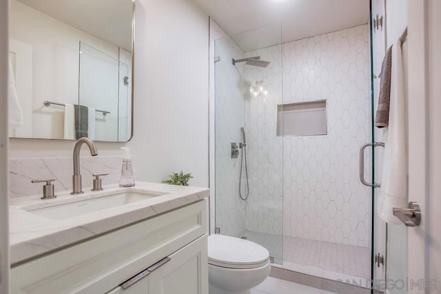 bathroom with toilet, vanity, and walk in shower