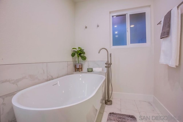 bathroom with a bathing tub and tile patterned flooring