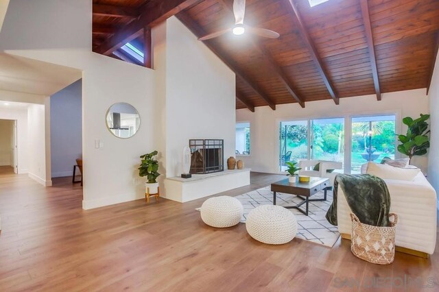 living room with beam ceiling, ceiling fan, wood ceiling, and hardwood / wood-style flooring