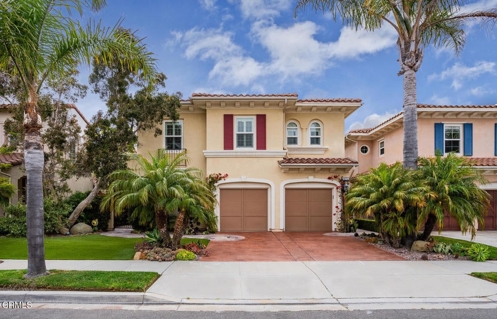 mediterranean / spanish-style home with a garage and a front lawn