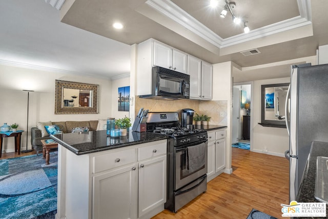 kitchen featuring backsplash, kitchen peninsula, light wood-type flooring, stainless steel appliances, and white cabinets