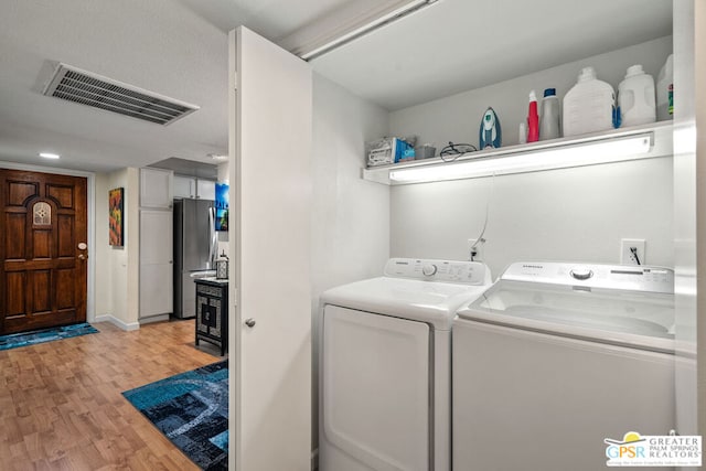 clothes washing area with light wood-type flooring and washing machine and clothes dryer