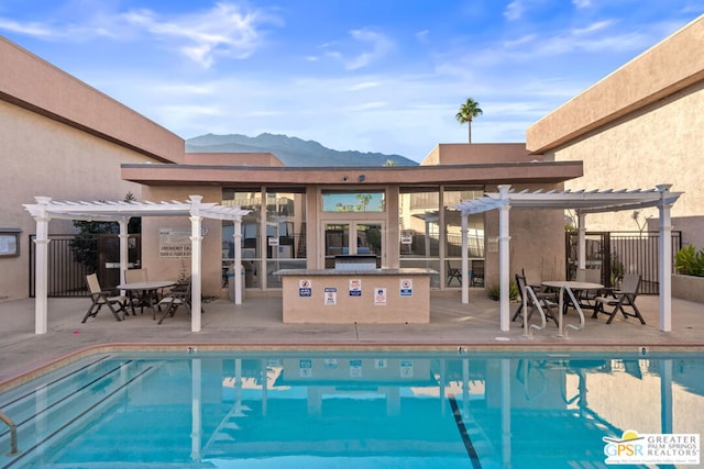 view of pool with a pergola, a patio area, and a mountain view