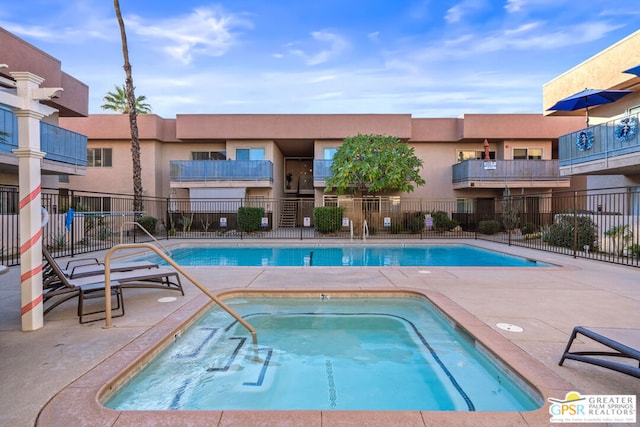 view of pool with a hot tub