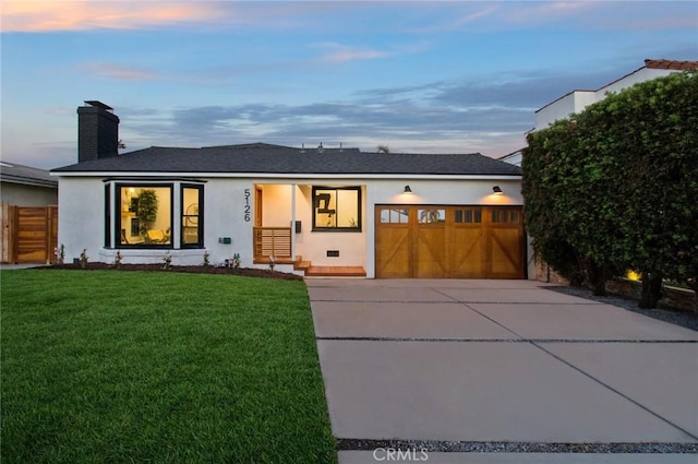 view of front of house with a garage and a yard