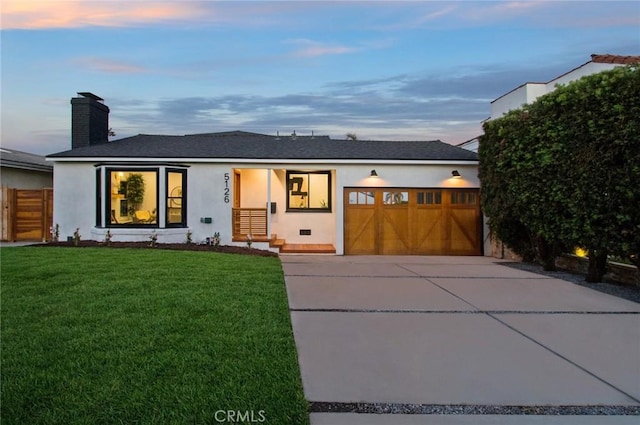 view of front of home featuring a garage and a yard