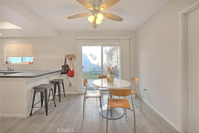 dining room featuring ceiling fan and sink