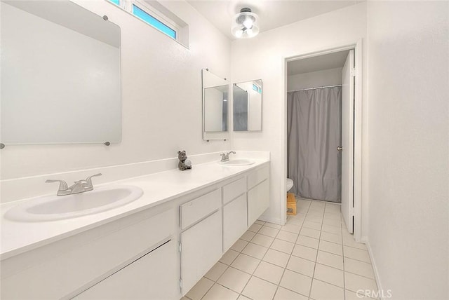 bathroom featuring toilet, vanity, and tile patterned flooring