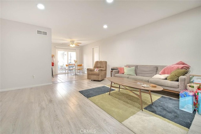 living room featuring ceiling fan and light hardwood / wood-style flooring