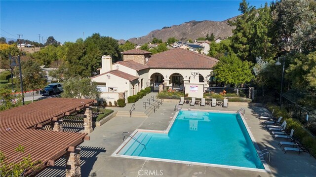 view of swimming pool with a mountain view and a patio