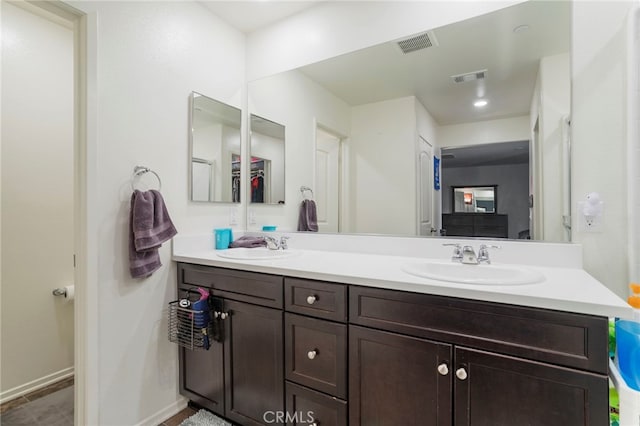 bathroom featuring visible vents, a sink, and double vanity