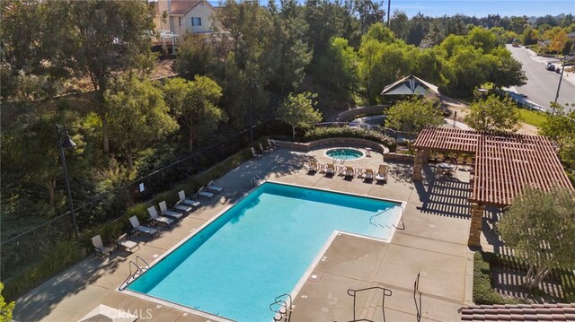 view of pool featuring a community hot tub and a patio area