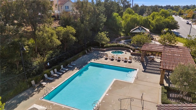 community pool featuring a patio area, fence, a hot tub, and a pergola