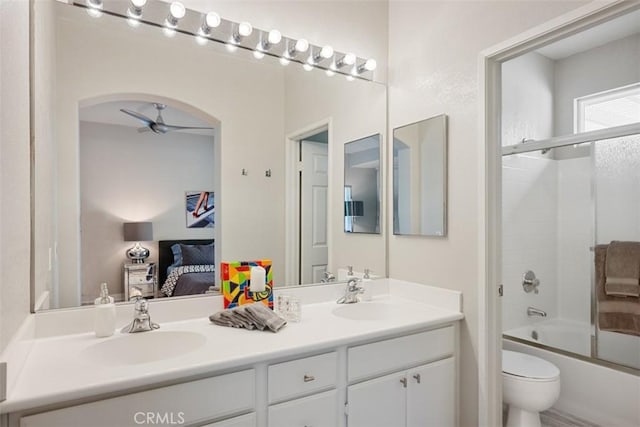 full bathroom featuring toilet, combined bath / shower with glass door, vanity, and ceiling fan