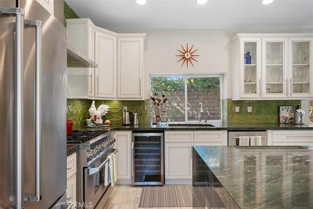 kitchen with sink, white cabinets, appliances with stainless steel finishes, and wine cooler