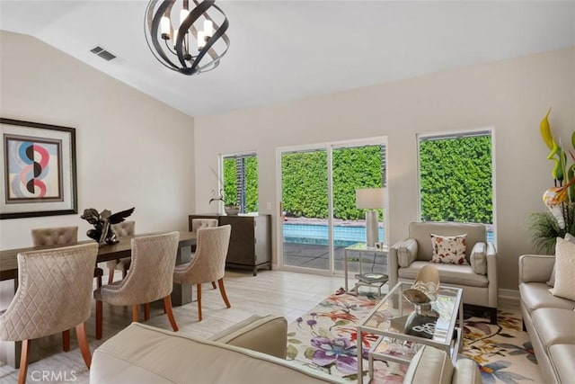 living room with vaulted ceiling and a notable chandelier