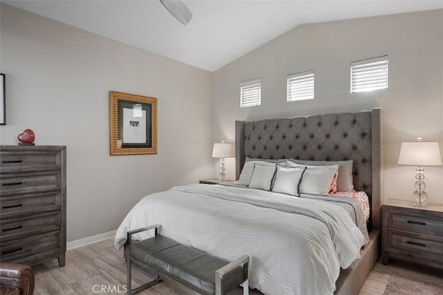 bedroom featuring ceiling fan, light wood-type flooring, and vaulted ceiling