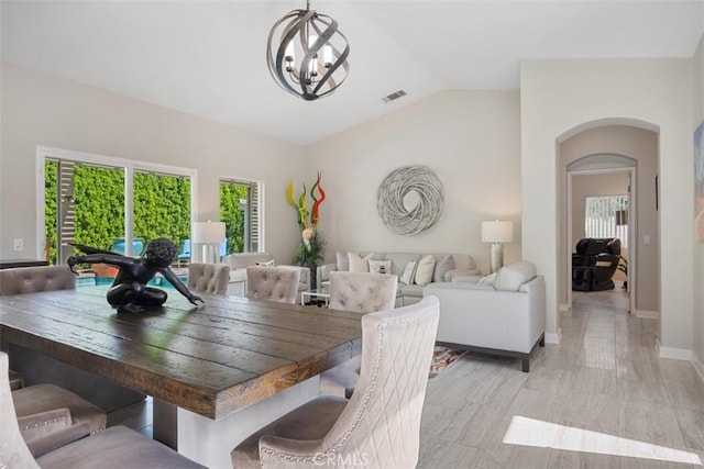 dining room with vaulted ceiling and a chandelier