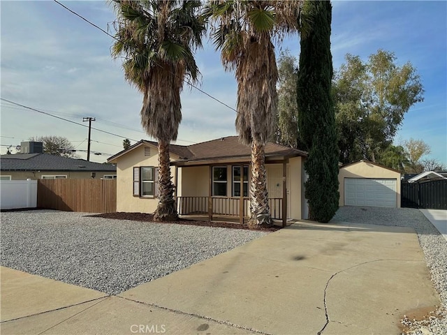 single story home with covered porch, a garage, an outbuilding, and cooling unit