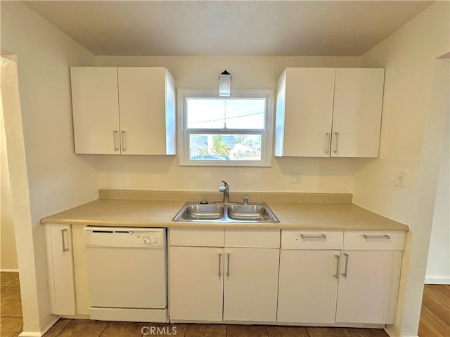 kitchen with white dishwasher, sink, white cabinetry, and tile patterned flooring