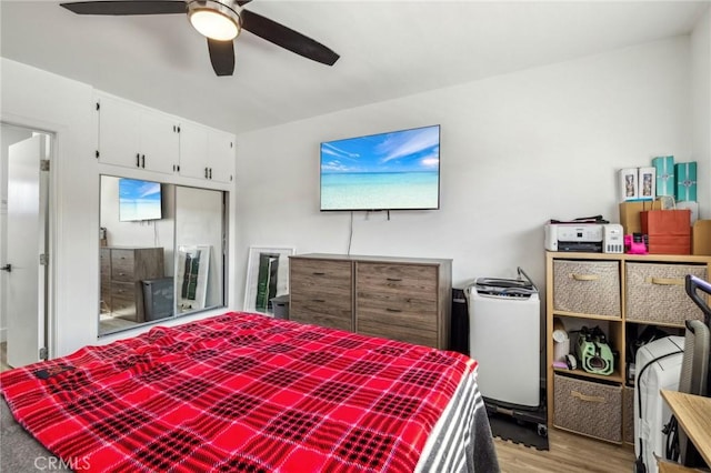 bedroom featuring ceiling fan, a closet, and light wood-type flooring