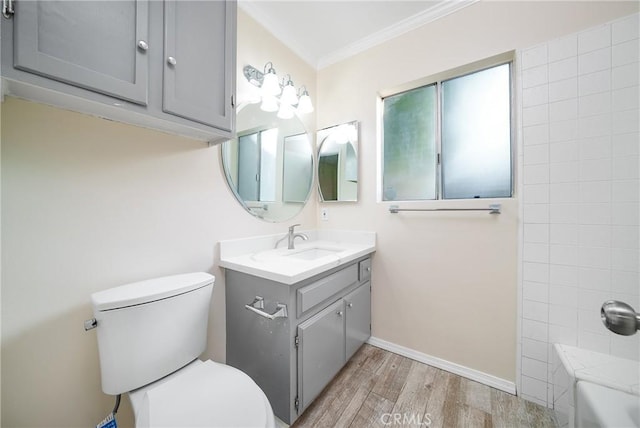 bathroom with wood-type flooring, toilet, vanity, and crown molding