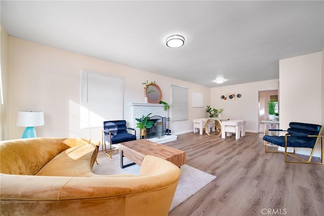 living room with a brick fireplace and light hardwood / wood-style flooring